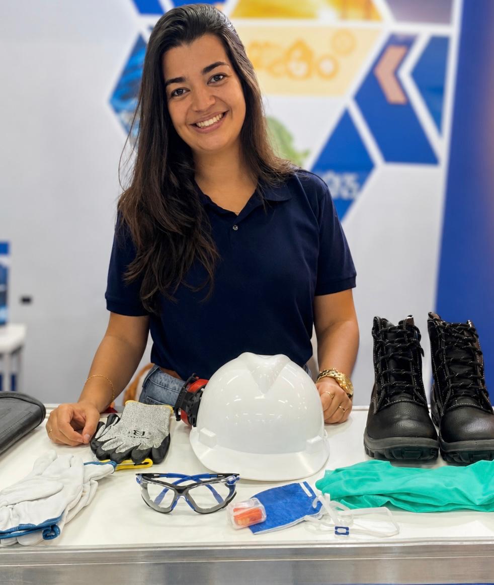 Fernanda G. Menezes Ferreira posando com EPIs (capacete, luvas, óculos, botas)
